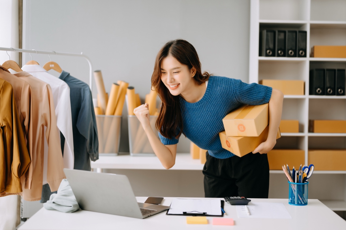 Online seller packing parcels with a laptop, Shopify GST/HST setup