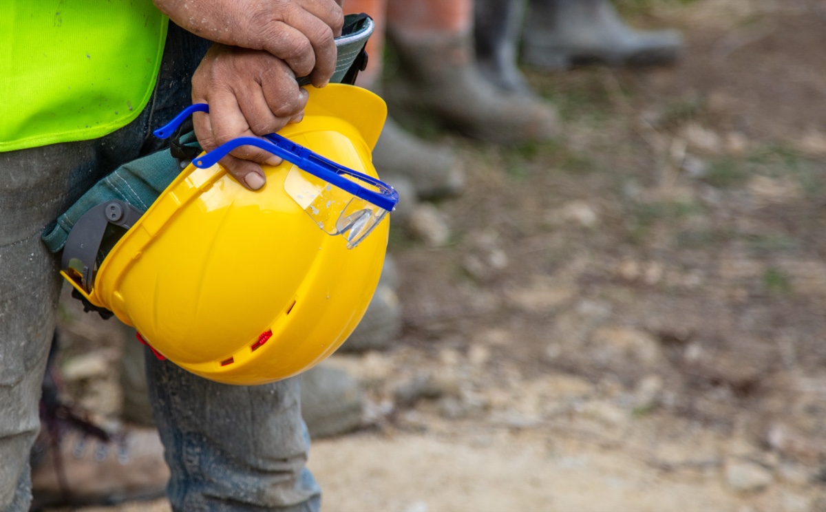 Construction worker holding a yellow hard hat, representing WorkSafeBC coverage for a BC small business
